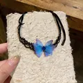 Macro view of a delicate blue chiffon butterfly choker with black lace and ribbon - Black