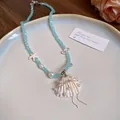 Elegant French style light blue beaded necklace featuring a white shell pearl pendant. - Shell Bowknot / Blue-White