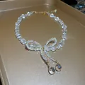 Elegant French style iridescent glass bead necklace featuring a delicate beaded bow pendant - Bow Pendant Style / Clear