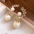 Dettaglio di orecchini pendenti vintage in oro e perle con cristalli scintillanti - Stile Pendente con Perno in Argento / Oro