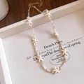 Close-up of a bohemian beaded necklace featuring elegant cream-colored starfish charms - Necklace-White