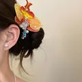 Close-up detail of a vibrant orchid flower hair clip with pearls worn on dark hair - Yellow Orchid Style / Single Piece / Yellow