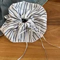 Gros plan sur un chouchou en tissu à rayures bleues et blanches avec rubans et nœud en métal - Élastiques Nœud Rayé