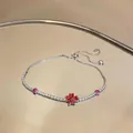 Detail view of an elegant silver zircon flower bracelet with red heart-shaped petals. - Red Heart Clover Flower Style (HB5459)
