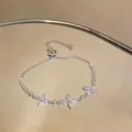 Close-up of silver-toned adjustable bracelet with sparkling zircon flower motifs - White Triple Flower Zirconia Style (HB5459)