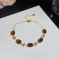 Elegant close-up of 18k gold plated bracelet featuring red stones and floral details - Red Oval Flower Style / Gold