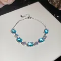 Detailed view of silver-plated bracelet with oval blue zircons and flower charms - Blue Oval Flower Style / Silver