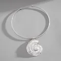 Detail view of a vintage silver textured conch shell pendant on a minimalist metal collar. - Silver