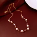 Detailed view of 18k gold plated pearl necklace on elegant vintage dark brown fabric. - Gold-White