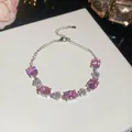 Elegant close-up of a silver bracelet featuring pink oval zircons and floral motif designs - Pink Oval Flower Style / Silver