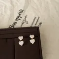 Detailed view of pink and white heart-shaped textured glass stud earrings in gold - Silver Earring Post Heart Studs / Gold-Pink