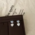 Close-up of sweet gradient glass heart stud earrings in unique blue and white - Silver Earring Post Heart Studs / Silver-Blue