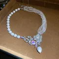 Detail of an elegant multi-strand beaded necklace with a crystal flower and pearl drop. - Asymmetrical Pearl Beaded Style / Silver