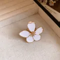 Detailed macro shot of a vintage white enamel flower ring with elegant gold-plated edges - White