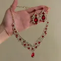 Elegant gold necklace and earrings set featuring vibrant red teardrop gemstones. - Lace Cluster Jewelry Set (2#)