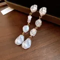 Dettaglio ravvicinato di eleganti orecchini vintage con perle barocche e nappe - Perno in Argento Stile Nappa Perla Irregolare (HE33218) / Oro