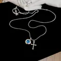 Detailed macro view of a silver necklace with blue star pendant and cross on black velvet - Round Star Cross Style / Blue