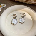 Close-up of sweet resin flower pendant earrings with pearl center in a silver-tone finish. - White