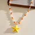 Gros plan détaillé d'un pendentif étoile de mer en résine jaune avec des perles colorées. - Jaune