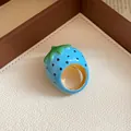 Close-up of a vibrant blue strawberry enamel ring with golden interior finish. - Strawberry Shape / Blue