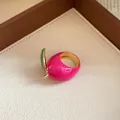 Close-up of a vibrant pink strawberry enamel ring with green leaf and gold plating. - Strawberry Shape / Oval / Gold-Pink