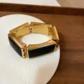 Gedetailleerde opname van een vintage gouden en zwarte rechthoekige schakelarmband - Goud met Zwart