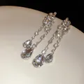 Detaillierte Makroaufnahme von eleganten Tropfenohrringen mit funkelnden Strasssteinen - Stil mit Silber-Ohrstecker / Silber-Weiß