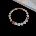 Detailweergave van een 18k vergulde armband met veelkleurige ronde zirkonastenen. - Ronde Steenstijl / Goud-Meerkleurig