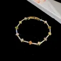 Gedetailleerd overzicht van 18 karaat vergulde armband met gekleurde zirkonia klavers - Klavertje Vier Stijl / Goud-Meerkleurig