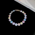 Gedetailleerde opname van een 18k vergulde armband met kleurrijke ronde zirkonia's. - Ronde Steenstijl / Zilver - Regenboog