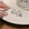 Close-up of elegant silver three-petal flower stud earrings with colorful zircon stones - Colorful