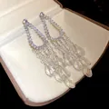 Detalle de pendientes colgantes con circón, perlas y cristales en una caja de regalo - Estilo Colgante de Borla y Perla (HE33213) / Plateado