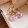 Nahaufnahme von eleganten rosa Kristall-Herz-Ohrhängern in einer luxuriösen Schmuckschatulle - Ohrringe / Gold-Rosa
