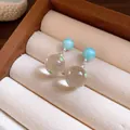 Detail view of icy transparent polka dot ball drop earrings with silver needles - Ball Pendant (Silver Post) / Blue