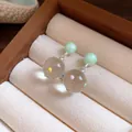 Close-up of elegant clear glass sphere earrings with colorful polka dots and green studs - Ball Pendant (Silver Post) / Green