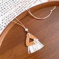 Detailed macro view of a bohemian style woven rattan triangle necklace with tassels. - Necklace-Beige-Coffee-Flower