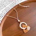 Detailed view of bohemian woven rattan triangle pendant with wooden ring - Necklace-Beige-Coffee-Triangle