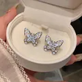 Close-up detail of silver hollow butterfly ear clips with sparkling zircon stones - Butterfly Ear Cuff / Silver