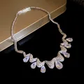 Close-up macro view of a sparkling silver zirconia teardrop necklace with wave pattern - Silver-White
