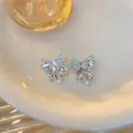 Close-up view of elegant light blue butterfly stud earrings with zircon and mini pearls - Bowknot Tassel Studs / 2.5cmx2cm / Silver-Blue
