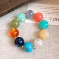 Detailaufnahme eines bunten Acrylperlen-Armbands auf einer dekorativen weißen Karte - Armband / bunt