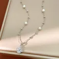 Close-up of elegant clover flower pearl necklace with sparkling CZ stones on beaded chain - Silver