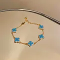 Detailed macro view of 18K gold-plated clover bracelet featuring turquoise resin accents - Style 3 Bracelet / Gold-Blue