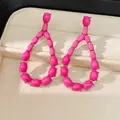 Primo piano di eleganti orecchini a goccia in pietra rosa shocking in un astuccio - Rosa Rosso