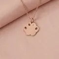 Close-up of a rose gold paw pendant necklace featuring a small sparkling crystal detail - Rose Gold