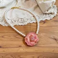 Elegant close-up of pink camellia pendant pearl necklace on a vintage lace background - Necklace-Pink-White