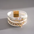 Detailed view of white multi-layer leather bracelet with gold heart charm and resin stone. - White