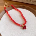 Detailed macro view of a red faceted crystal beaded necklace with a heart pendant. - Choker Necklace / Red