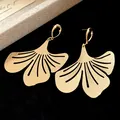 Close-up of gold metal ginkgo leaf drop earrings with sandblasted texture details - Gold