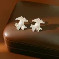 Detailed view of silver needle fan-shaped zircon earrings with white pearls on box - Scalloped Fan Style (HE33845) / Silver